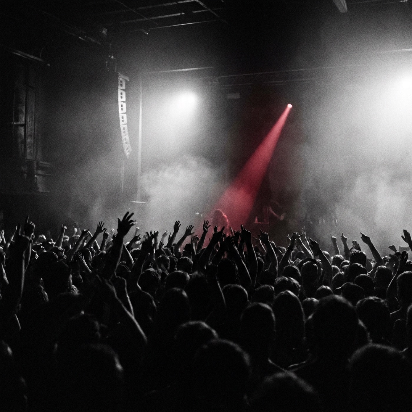 A dim stage washed in red, silhouette at the microphone